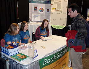 image of students signing book copies 