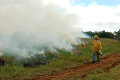 image of man walking near prescribed burn