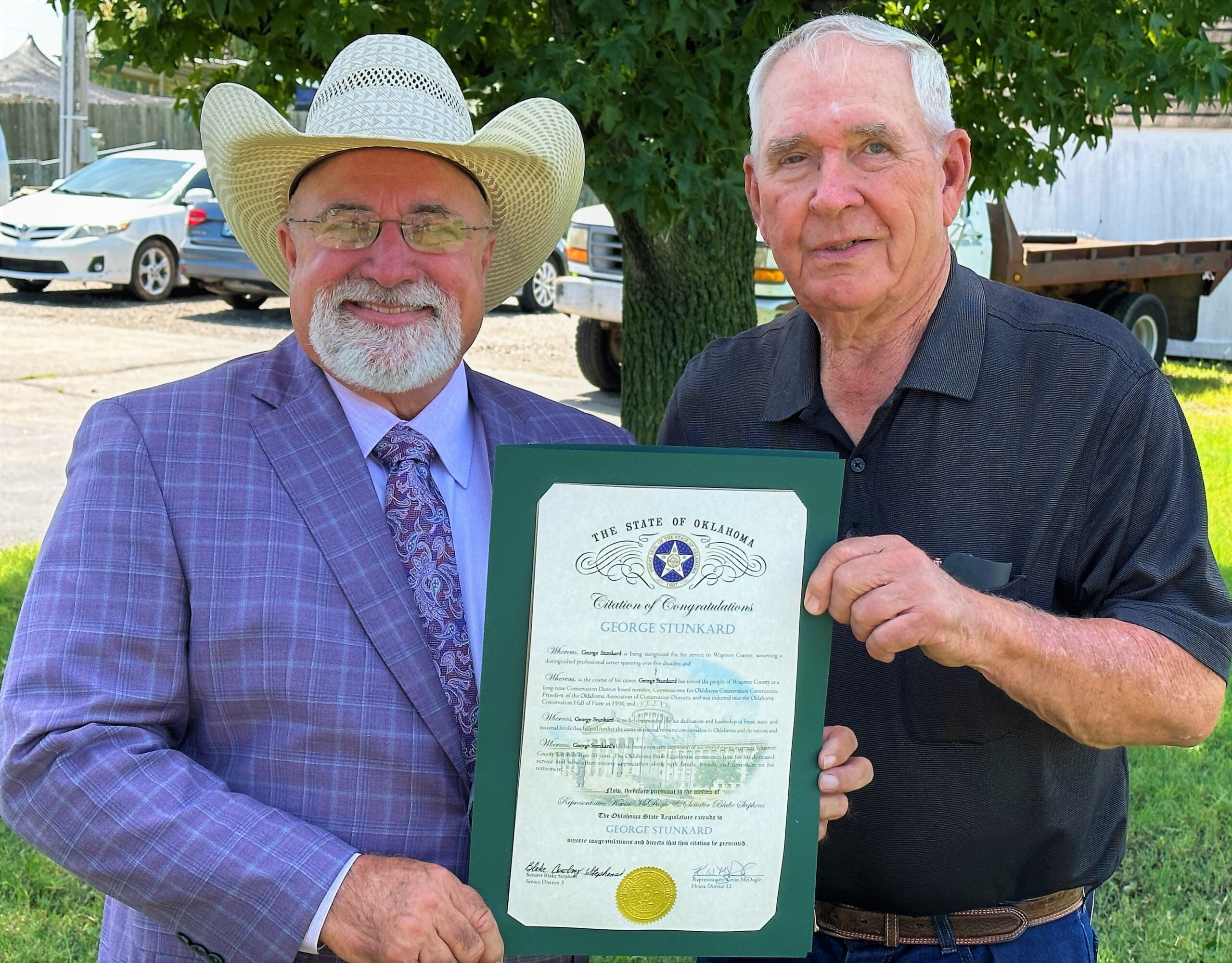 Senator Blake Stephens presents George Stunkard with a citation from the Oklahoma State Legislature recognizing his service. 